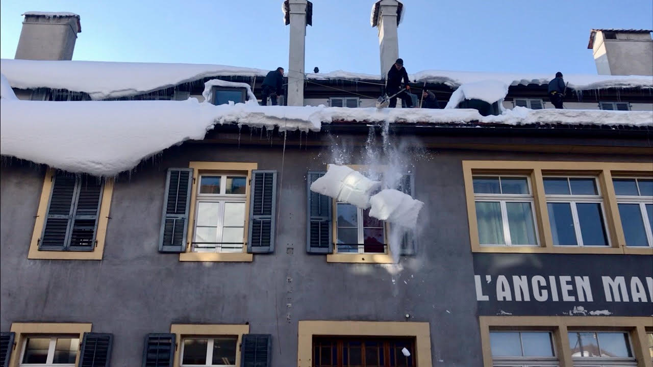 Déneigement de toiture en hiver par l'équipe Fahrni Toitures
